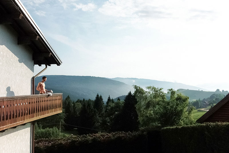 Ragazzo affacciato in terrazza di montagna